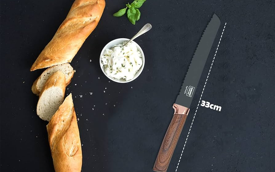 Knife next to baguettes and a bowl of spread on a dark surface