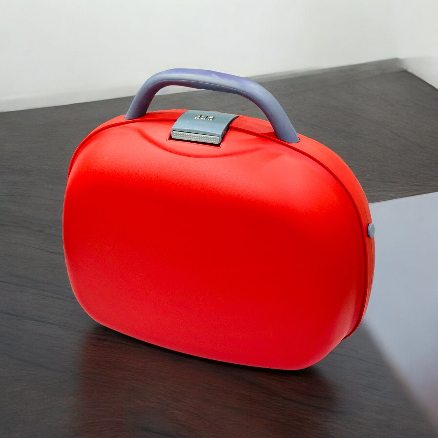 A red and green plastic combination beauty case with a handle and a mirror, placed on a wooden surface.
