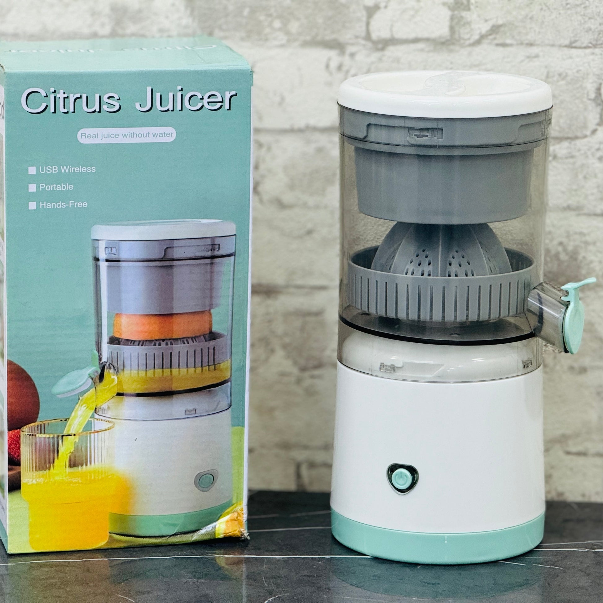 A portable and wireless rechargeable fruit juicer squeezer next to its packaging box. The juicer is predominantly white with green accents, and it appears to be made of plastic with a glass container.
