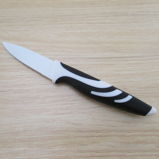 Paring knife with a black and white handle on a wooden surface