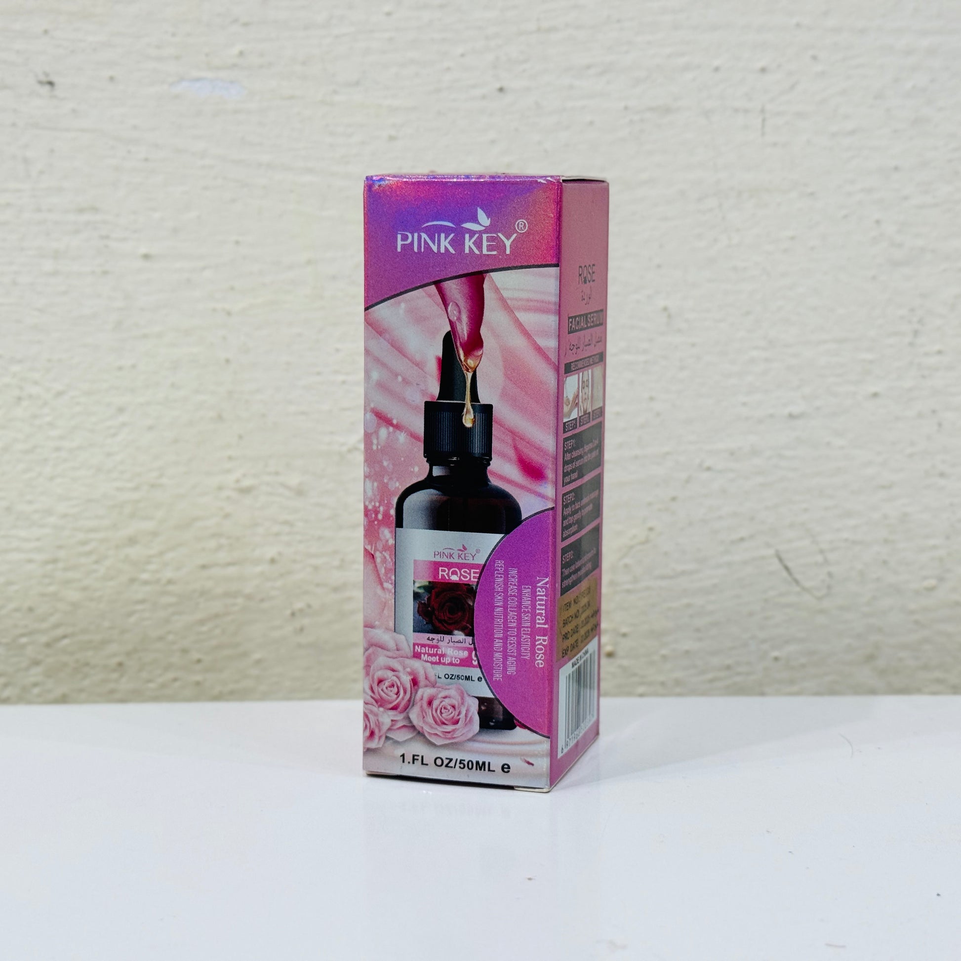 Pink Key bottle and box on a white surface with a light gray background