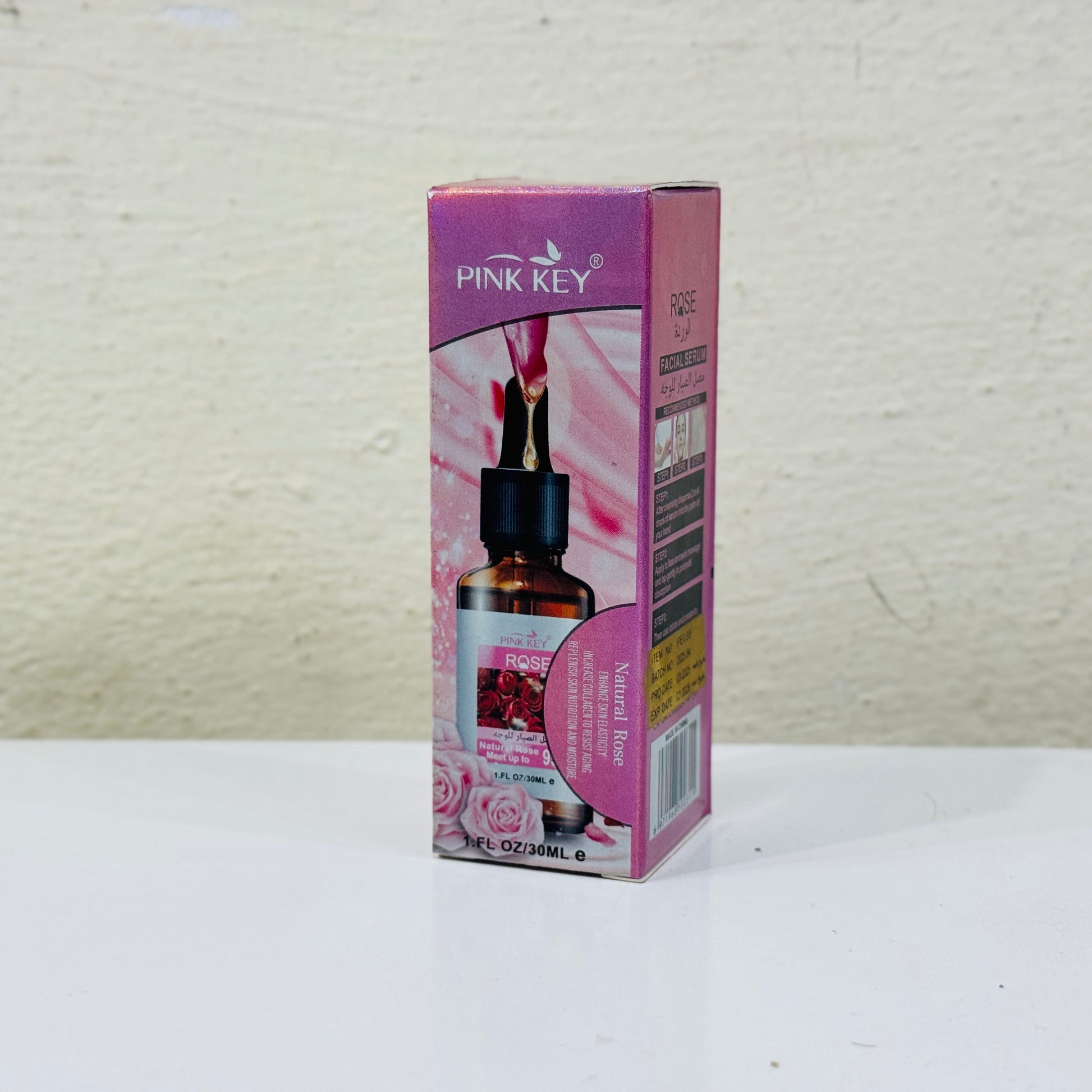 Pink Key essential oil bottle and packaging on a white surface with a light gray background
