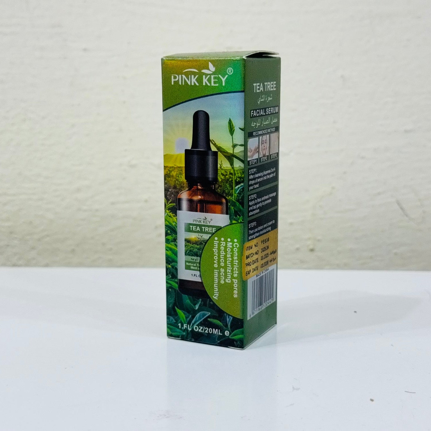 Pink Key Tea Tree oil packaging on a white surface with a light gray background