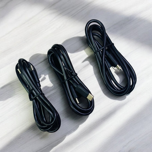 Three black USB-C to USB-C cables laid out on a light surface.