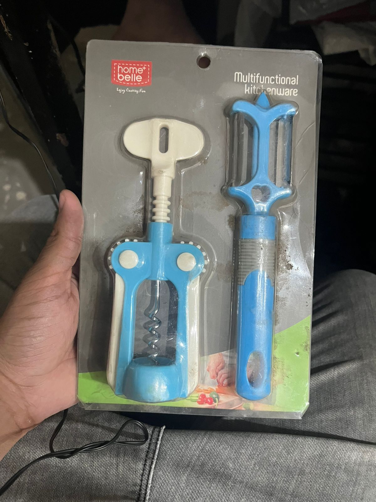 Multifunctional kitchenware set in packaging held by a person.