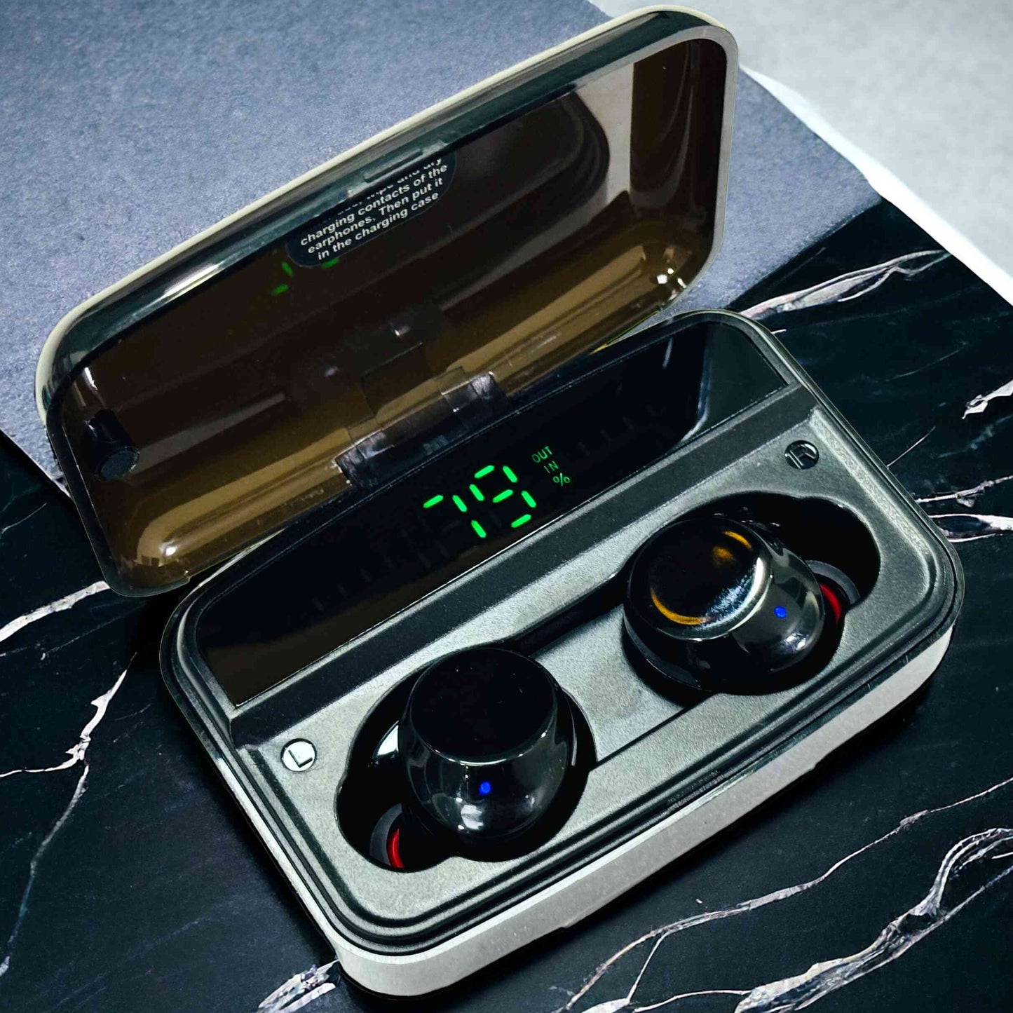 Wireless earbuds in a charging case on a marble surface