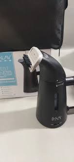 Black handheld steamer on a white surface with a blurred background