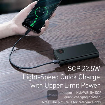 Person charging a phone with a power bank on a wooden surface, featuring Besouts branding.