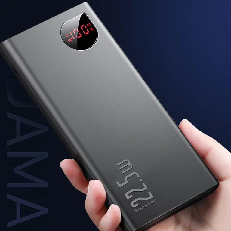 Black power bank held in a hand with a dark background