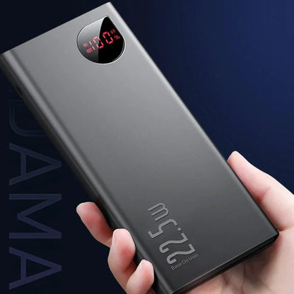 Black power bank held in a hand with a dark background