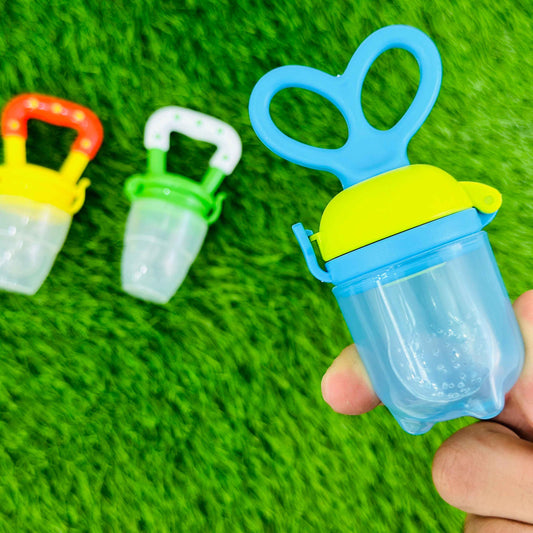 Colorful baby pacifiers on a green textured background