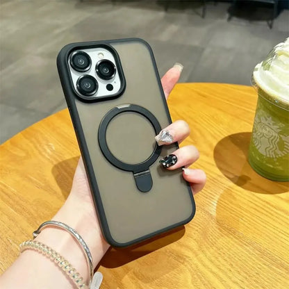 Hand holding a phone case with a ring holder on a wooden table with a Starbucks drink.