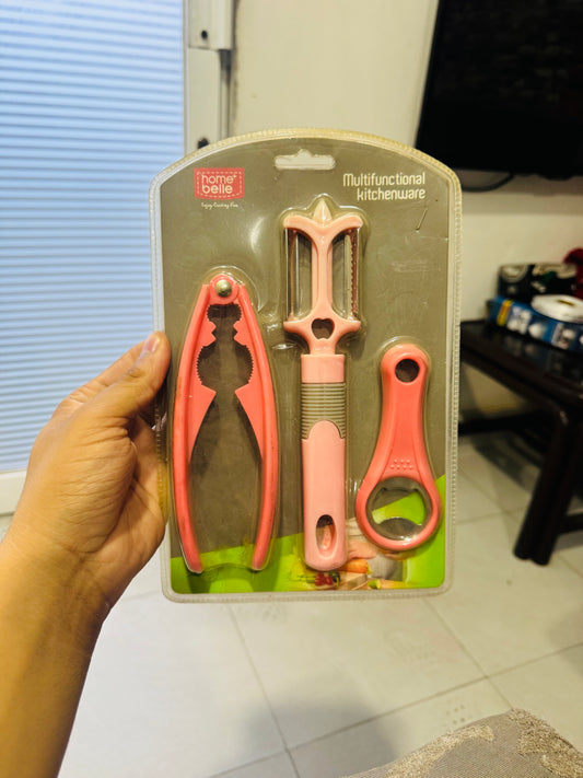 Hand holding a set of pink kitchen utensils on a cardboard backing with 'Home Basics' branding.