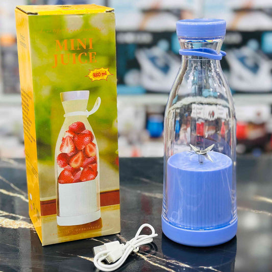 Blue bottle with a power cord next to a box labeled 'Mini Juice' on a reflective surface.