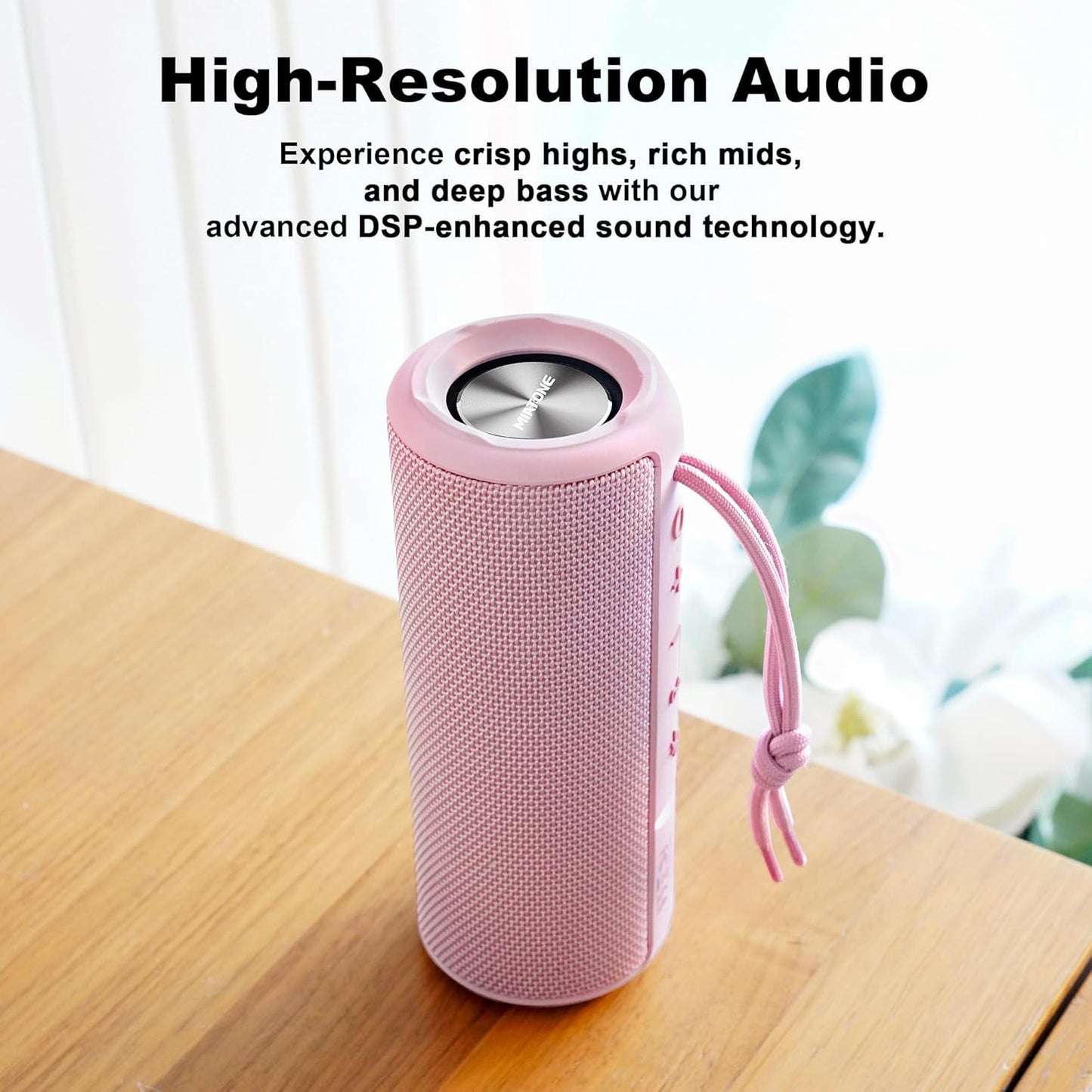 Pink portable speaker on a wooden surface with text about high-resolution audio.