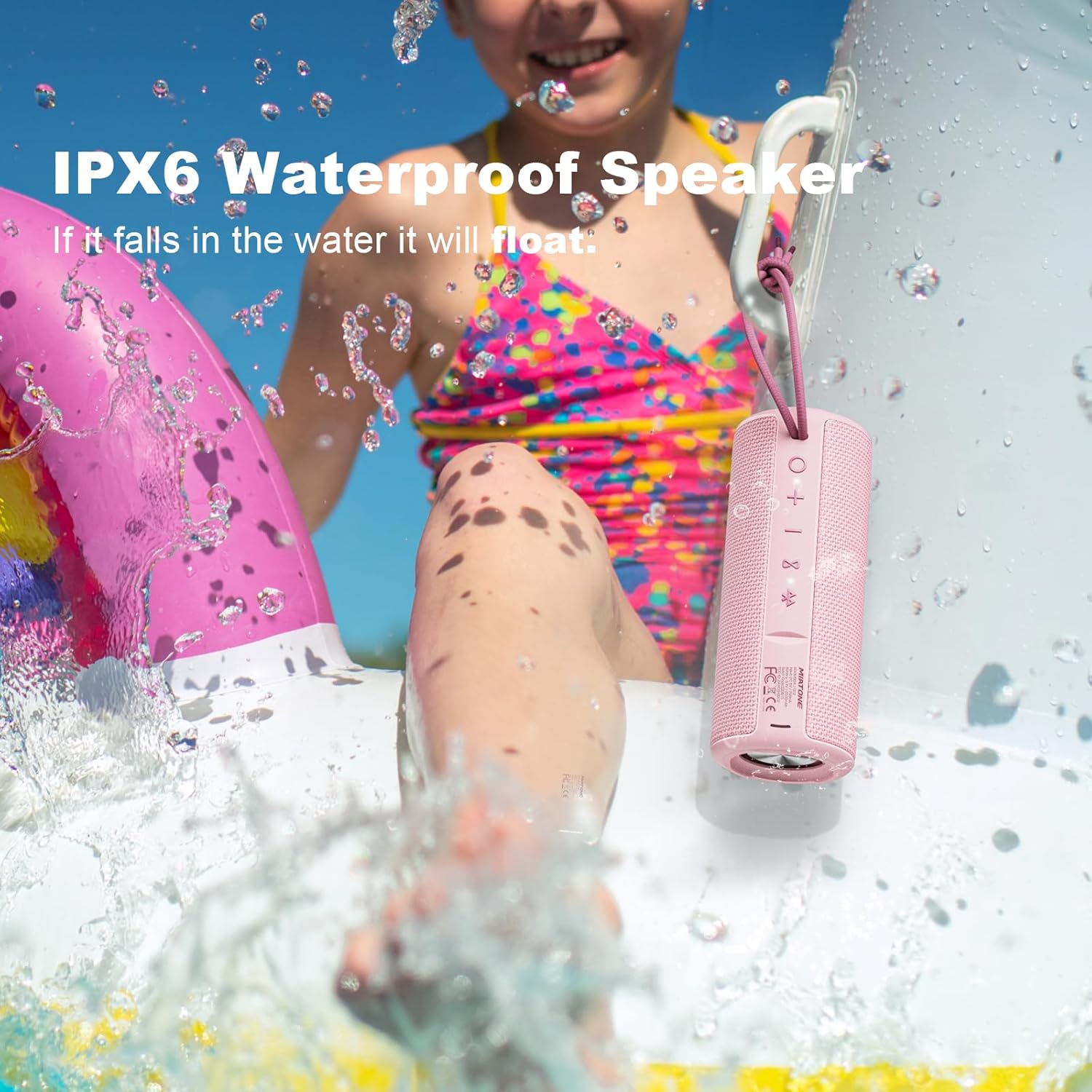 Pink waterproof speaker with a child playing in water, text indicating it floats if dropped.
