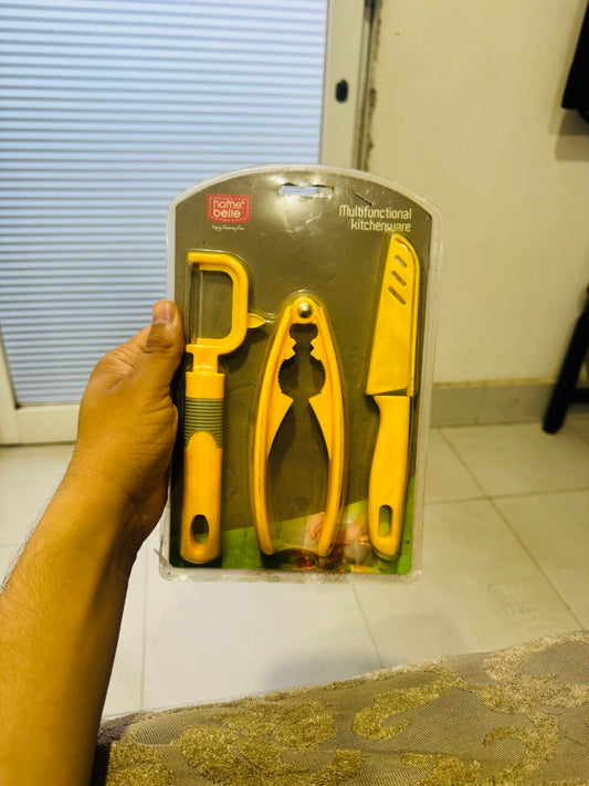 Set of yellow kitchen tools in packaging held by a hand on a tiled floor.