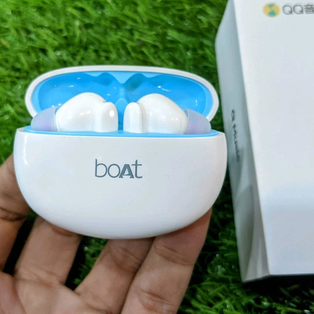 White and blue earbuds in a case held by a hand on grass