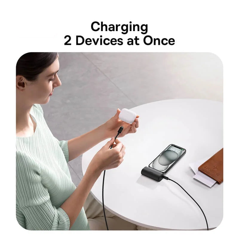 Woman using a baseus charging cable to charge two devices at once, with the brand logo visible.