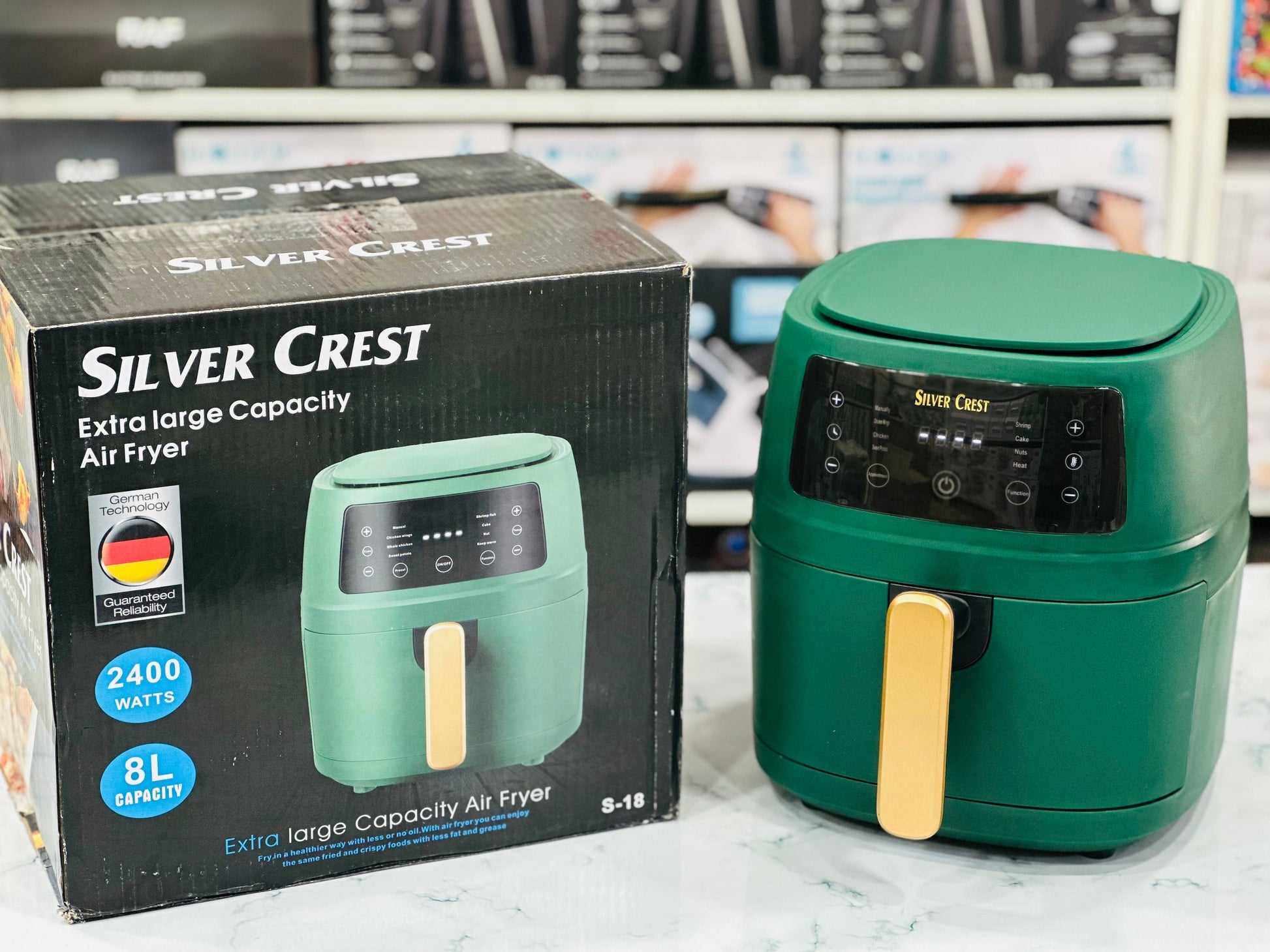 Silver Crest Digital Air Fryer in green color with a 8L capacity, displayed alongside its packaging box.