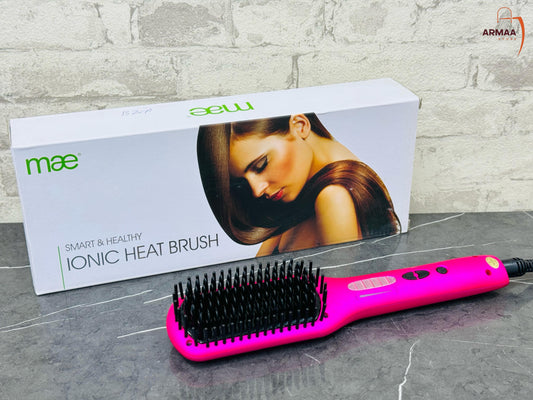 A pink Mae Brush hair straightener Iconic Heat Brush with metallic heat-resistant bristles, displayed next to its packaging box.